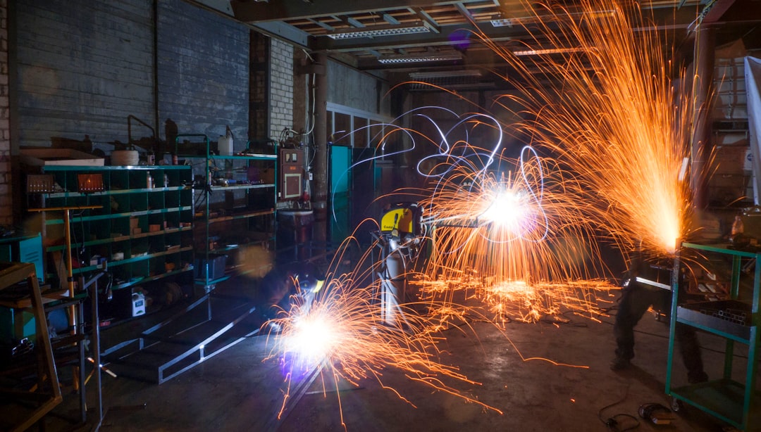 Robotic welding cell with sparks in an industrial manufacturing environment