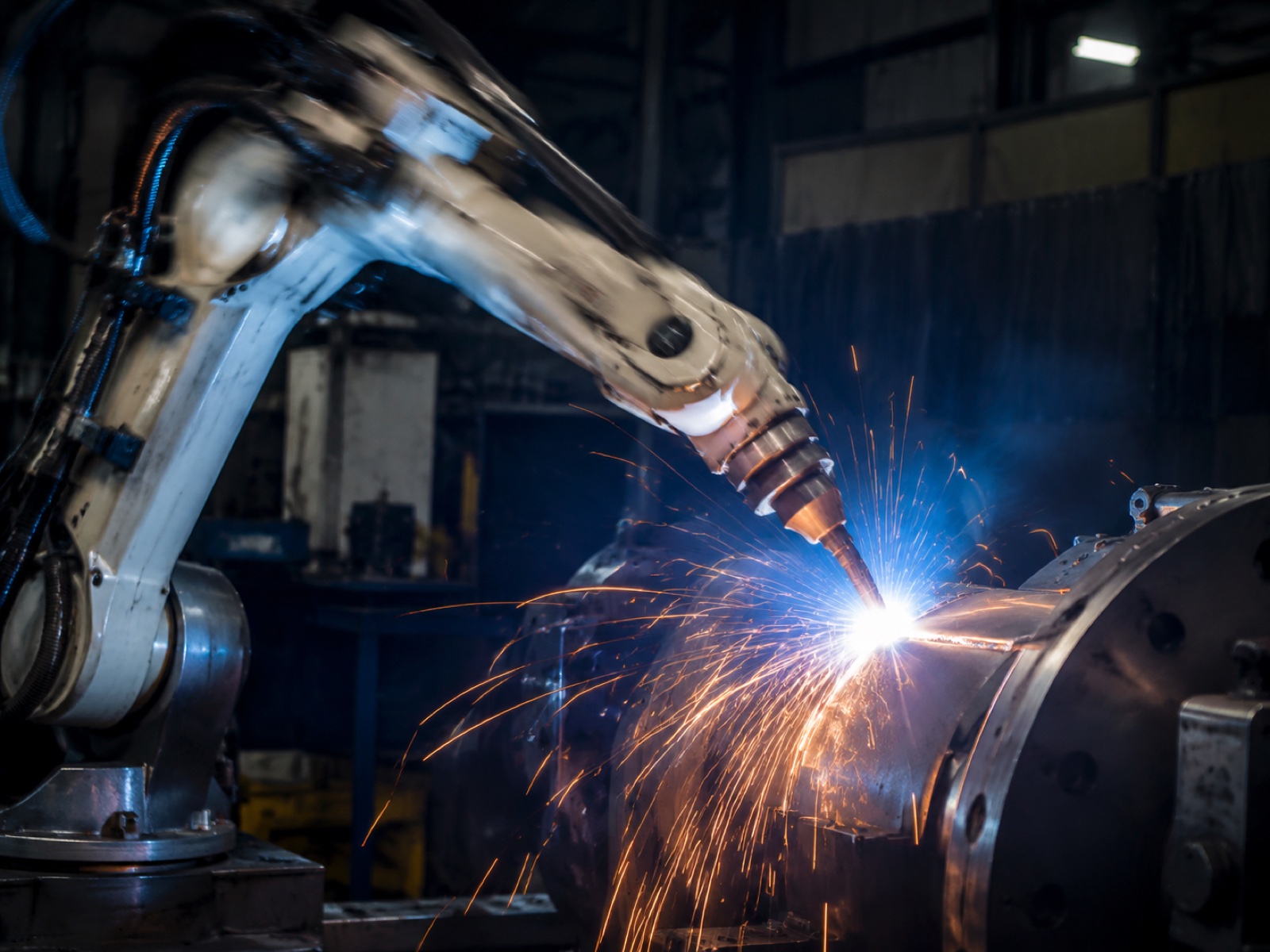 Robotic welding torch in high-speed motion along a steel seam with motion blur and bright welding arc illustrating cycle time advantage