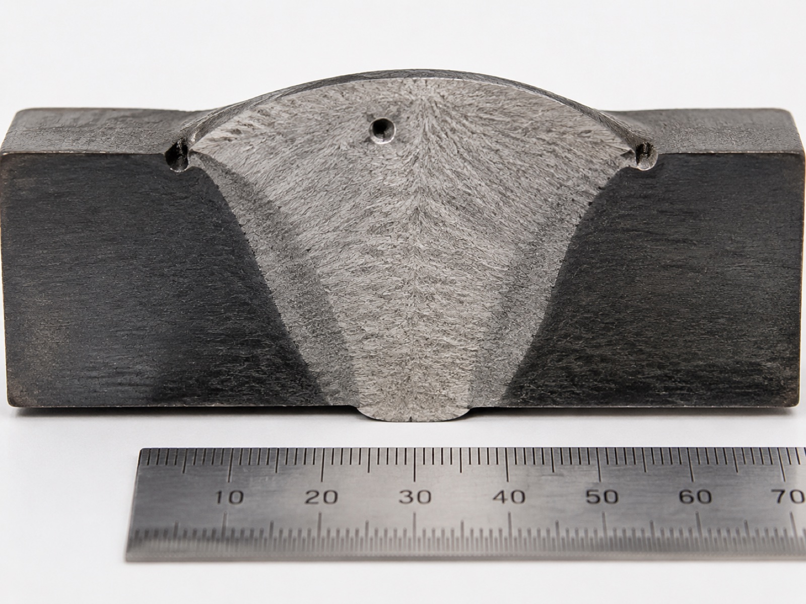 Polished weld macro cross-section showing fusion zone, HAZ, and visible defects including porosity and undercut for ISO 5817 grading