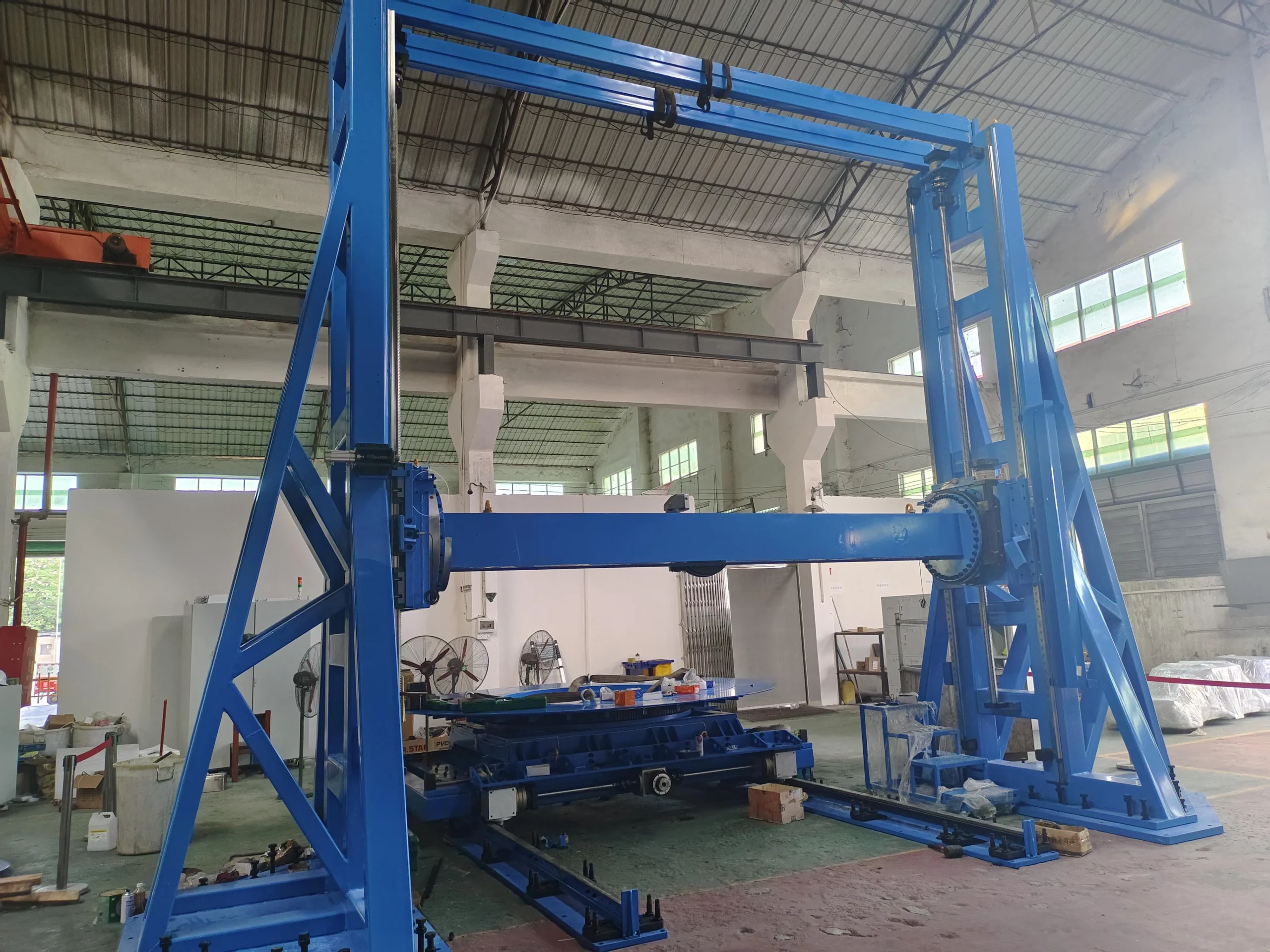 Blue custom heavy-duty gantry motion system in a production workshop