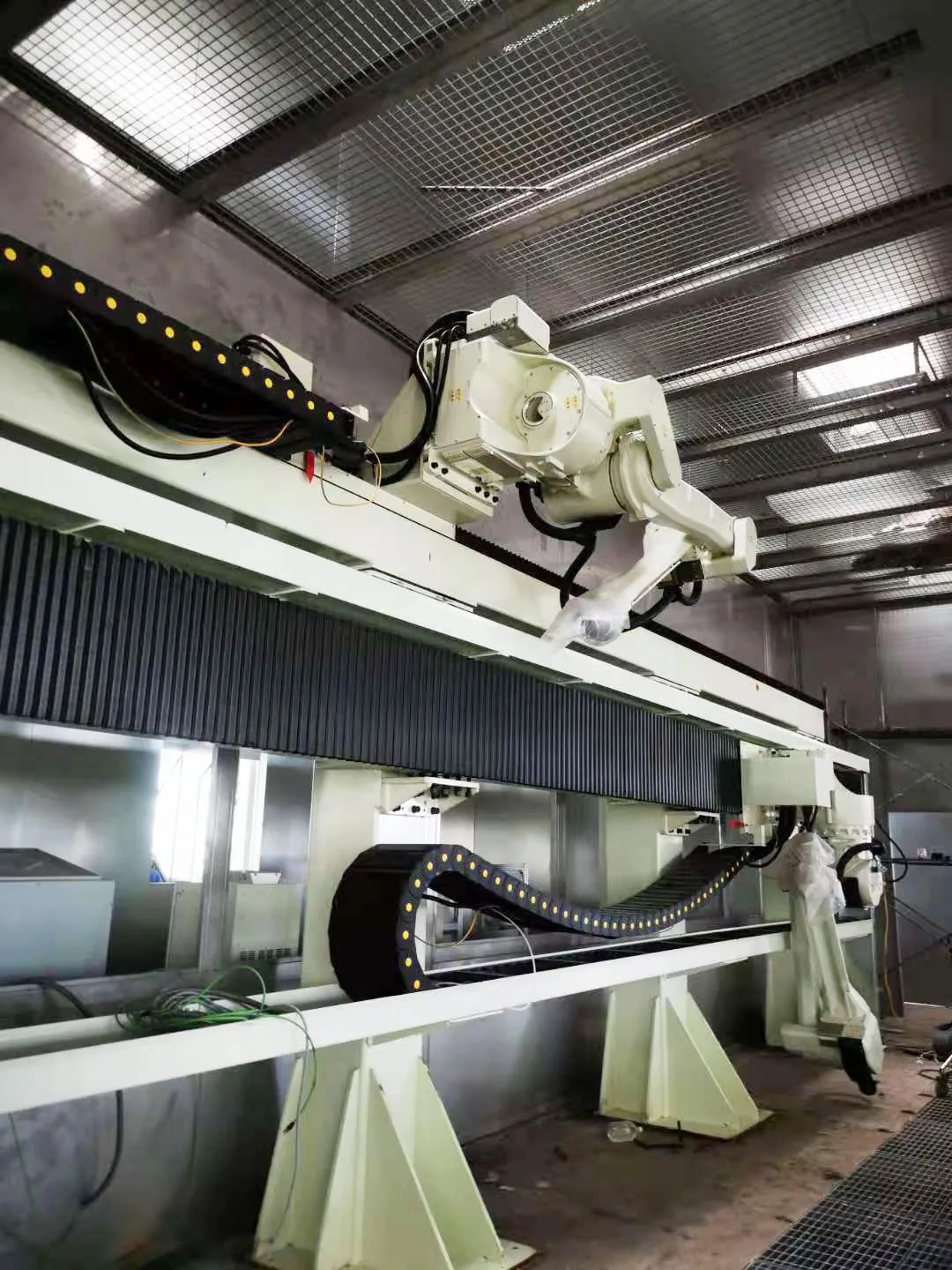 Elevated robot track carrying a robot above a work area
