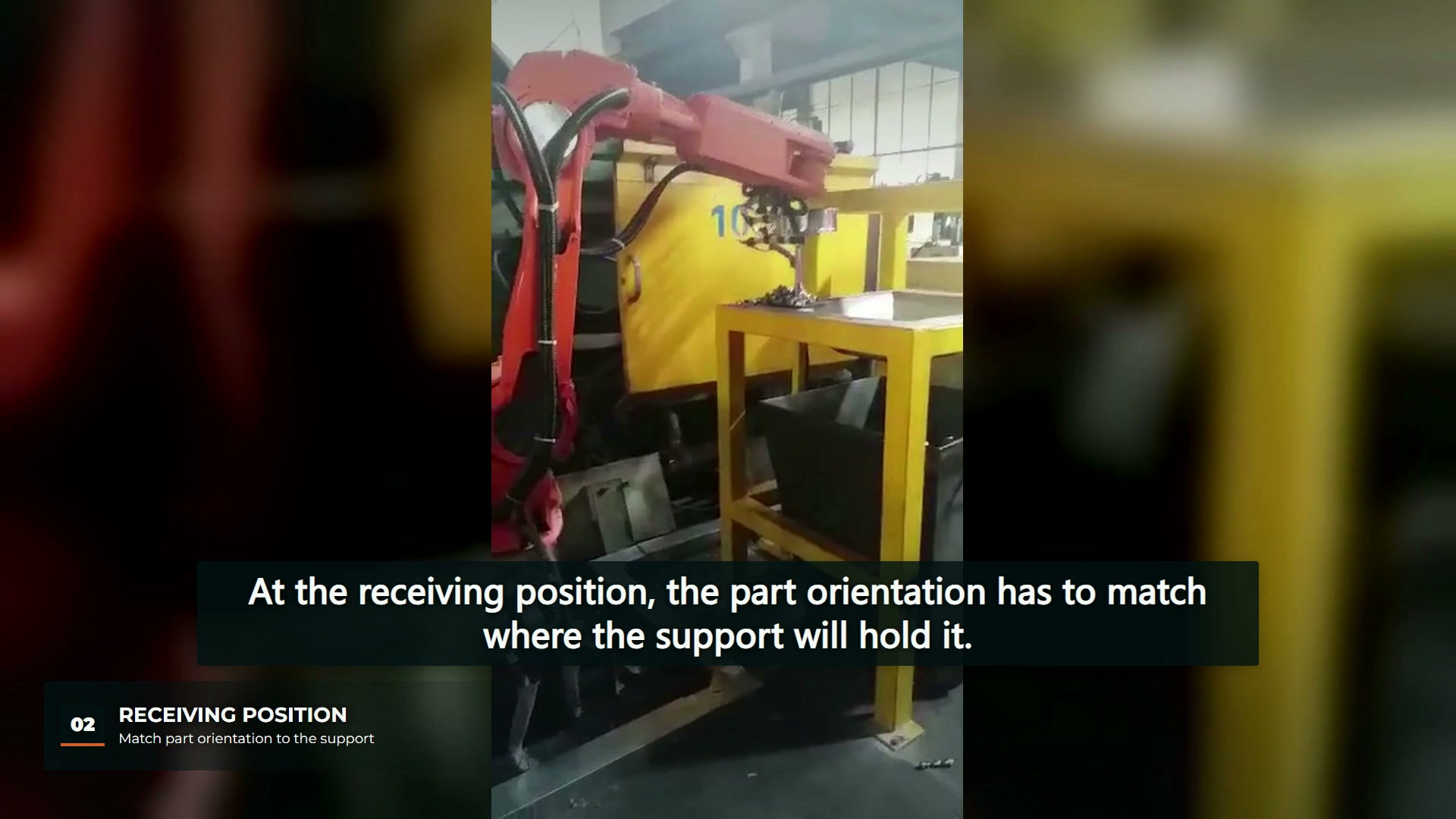 An orange robot brings a part to a yellow receiving stand beside a die-casting machine