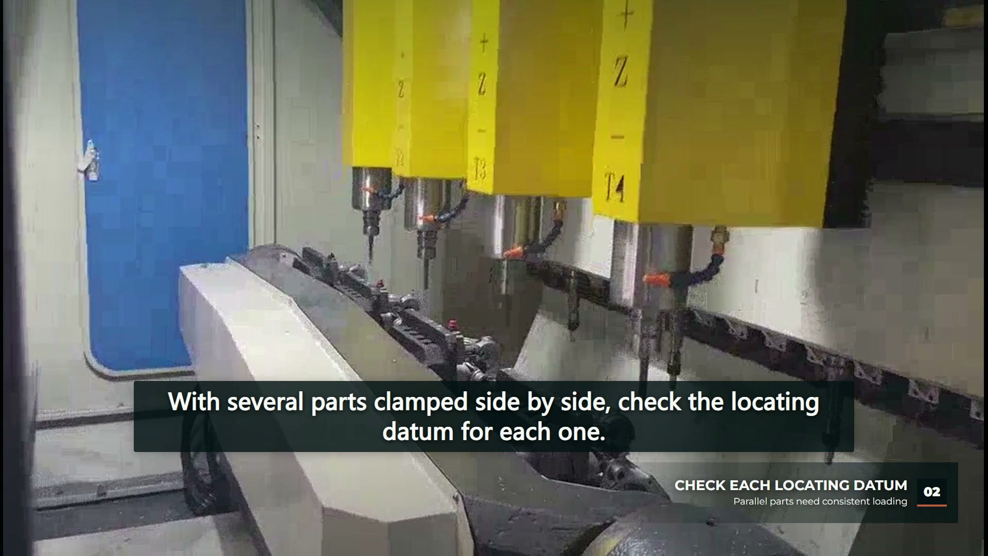 Four upper machining heads above a row of fixtures and workpieces.