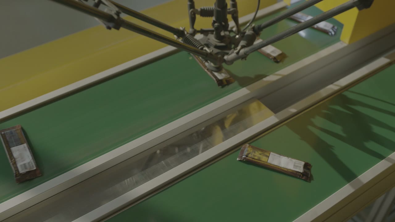 The robot moves across to the second belt