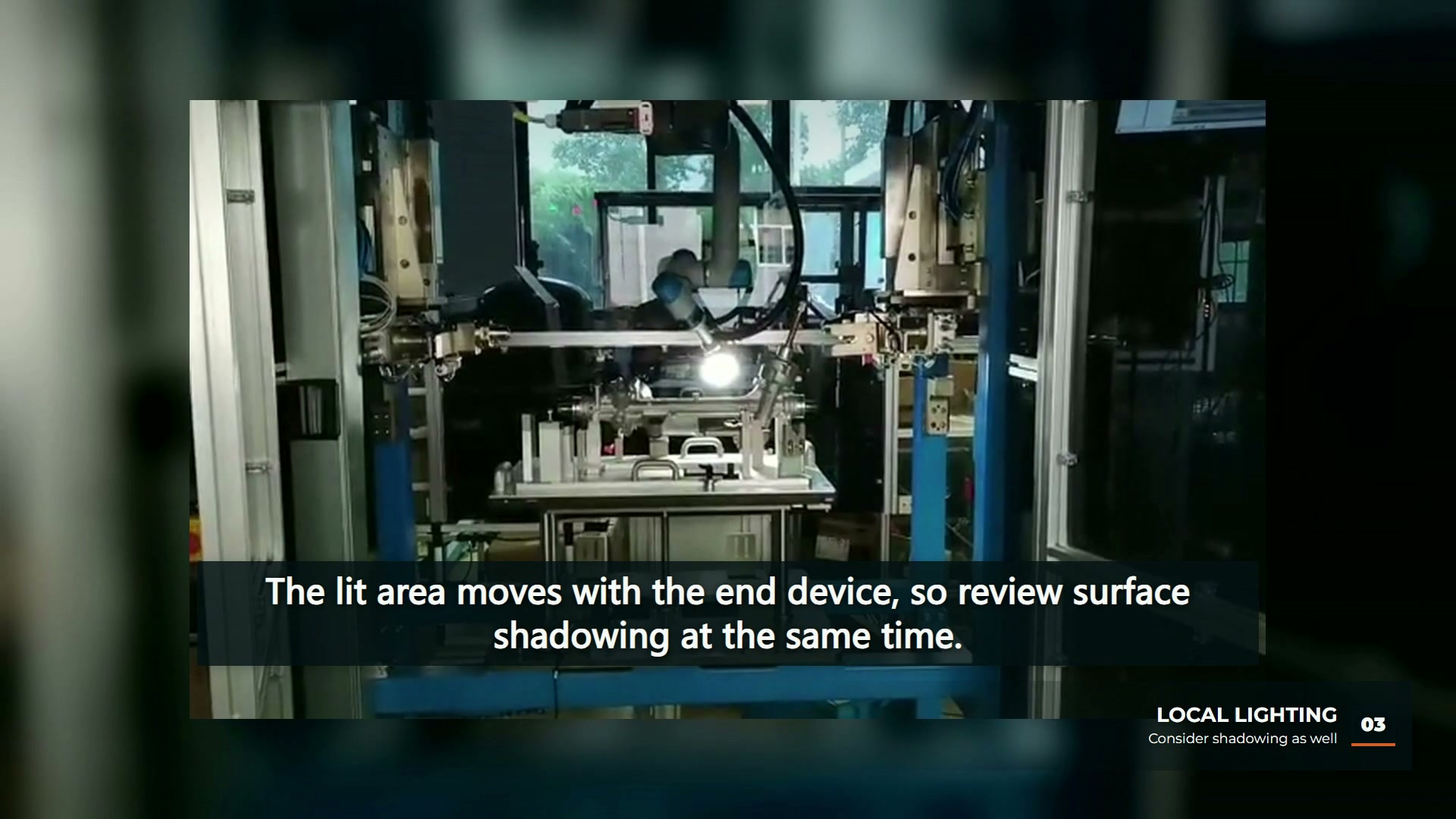 A robot moves a small light over a fixed part inside an enclosed inspection cell