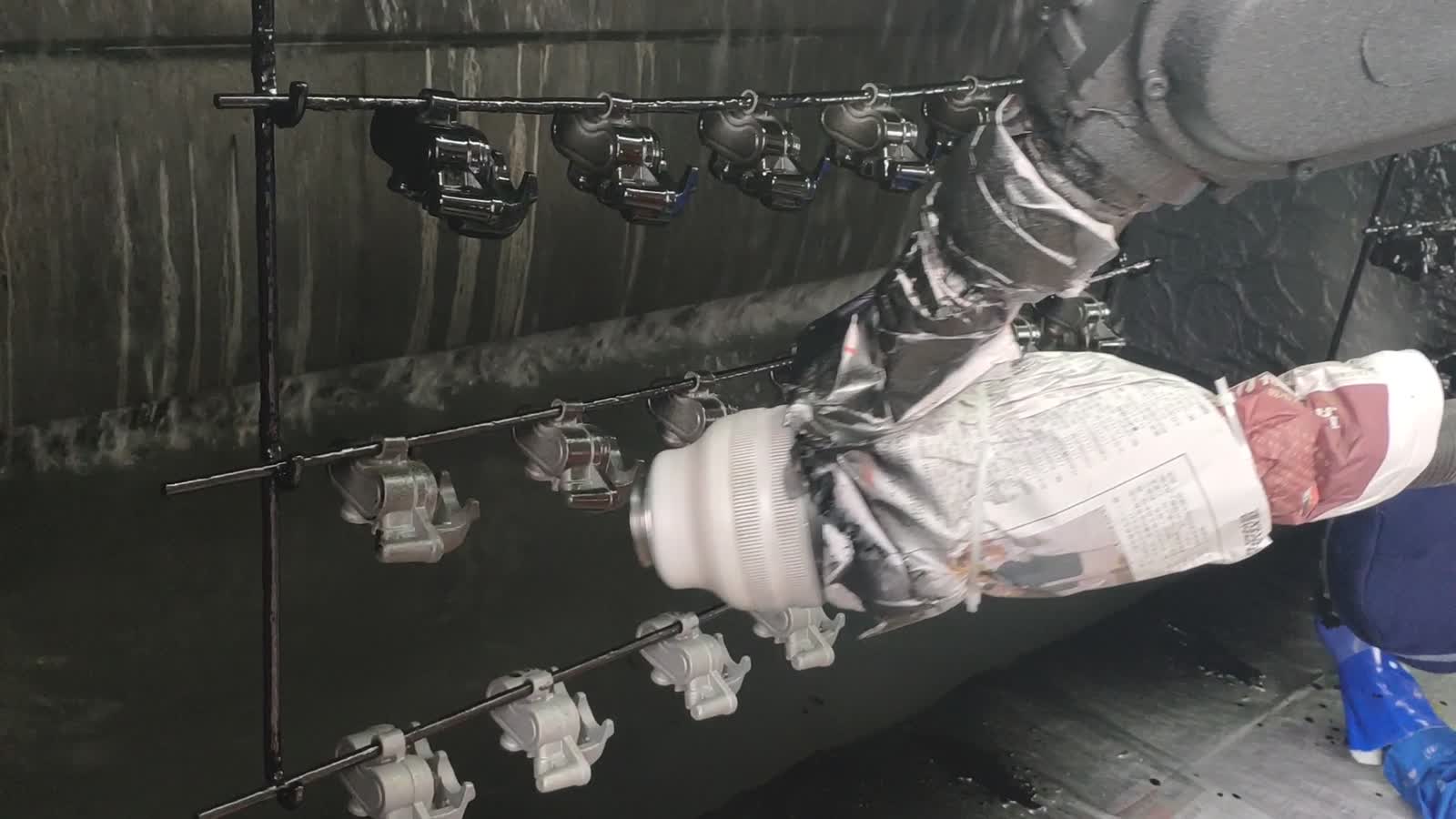 Parts hang in rows from a horizontal bar