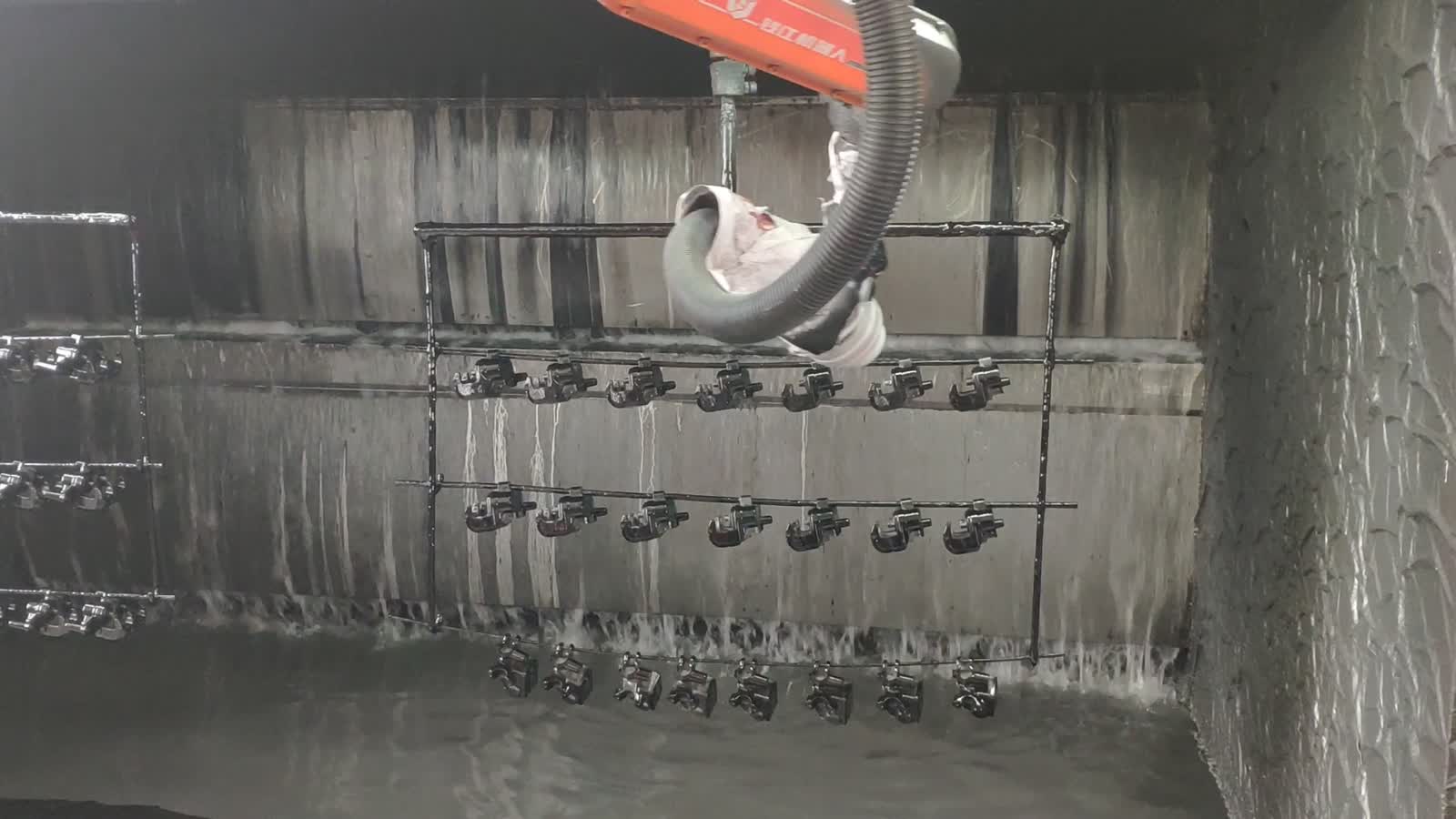 The water curtain on the back wall of the booth, running into a floor trough