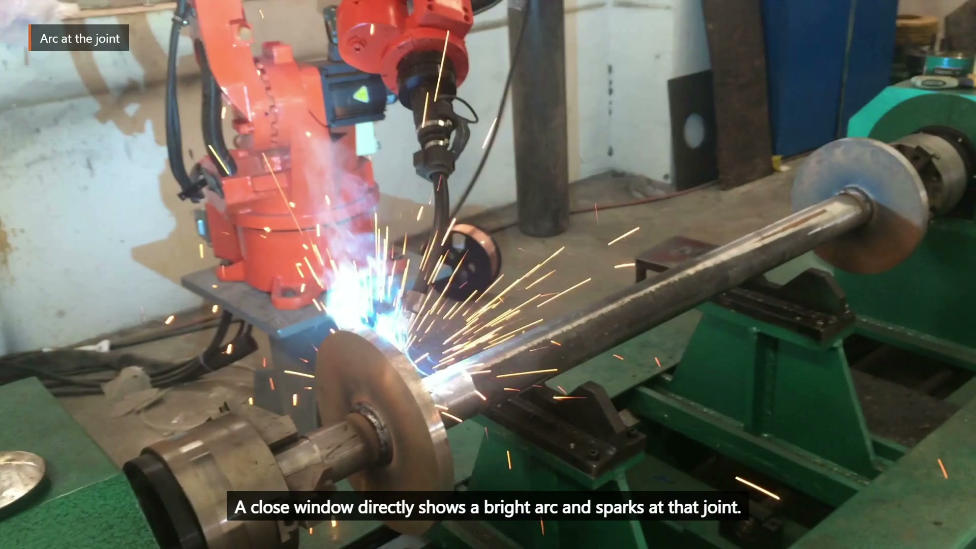 A bright arc and sparks are visible at one circular plate-to-shaft interface.