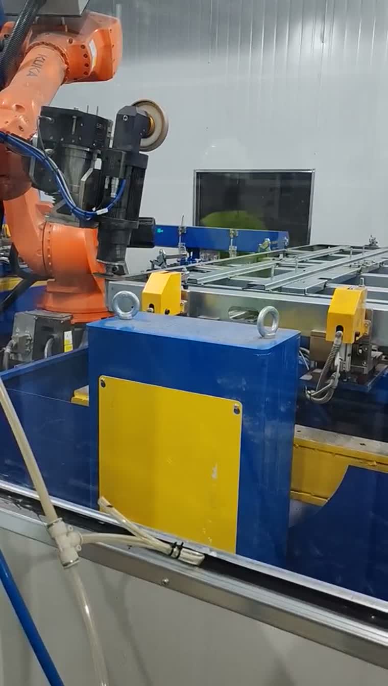 Robot-held finishing head beside an aluminum frame