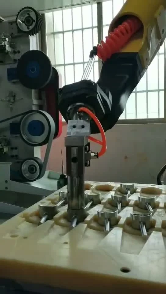 Robot gripper picks a small component from a locating tray