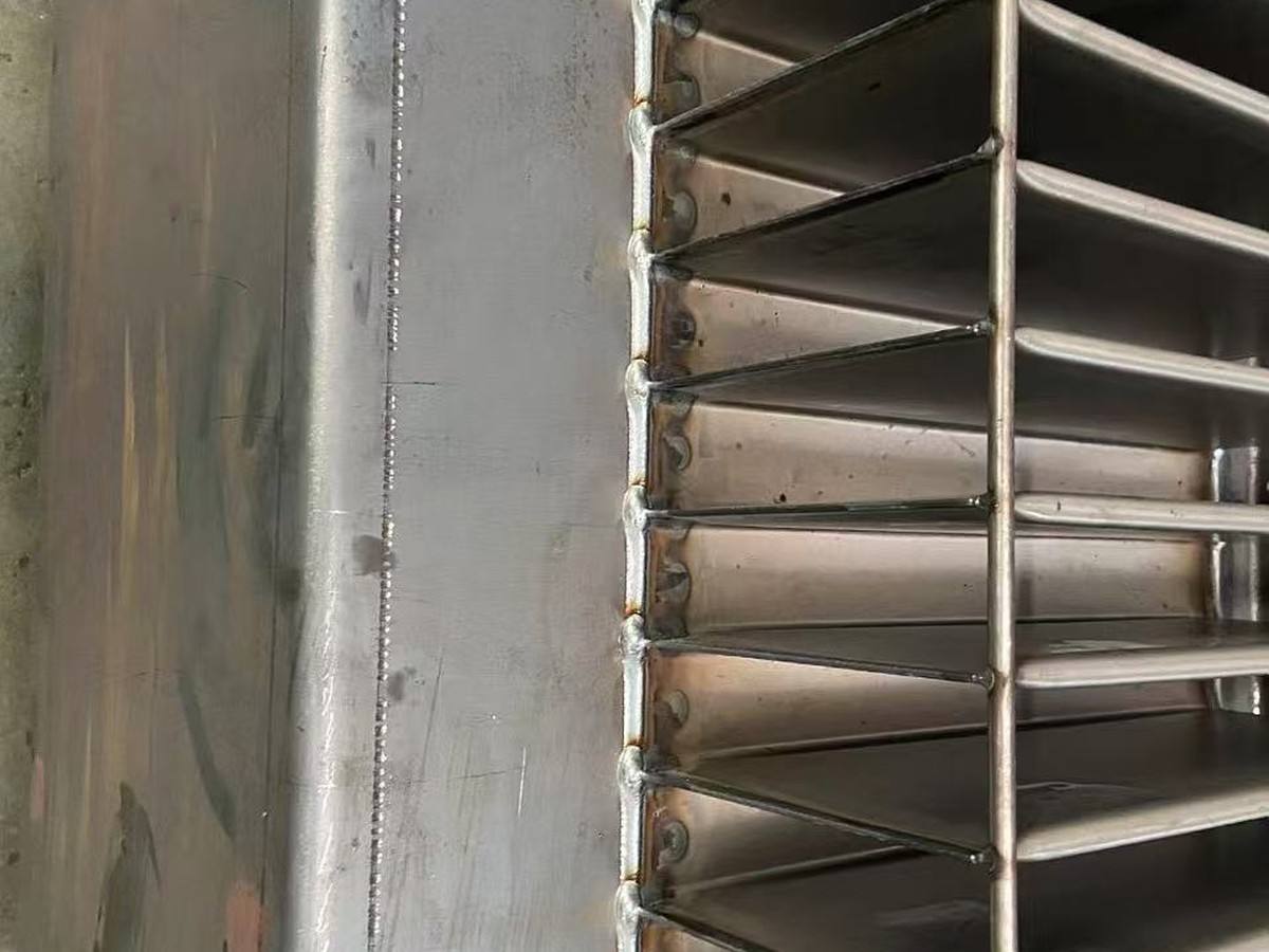 Close-up of corrugated transformer tank fins welded to a steel wall