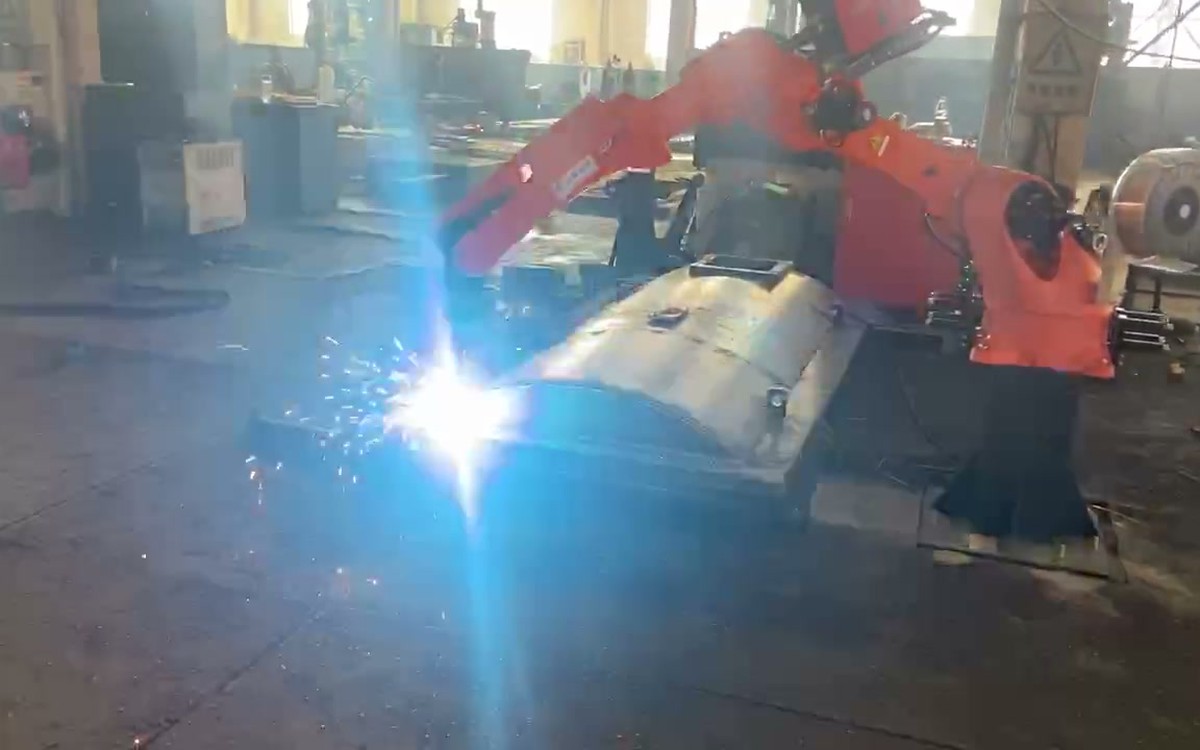 Robot welding a curved transformer tank cover