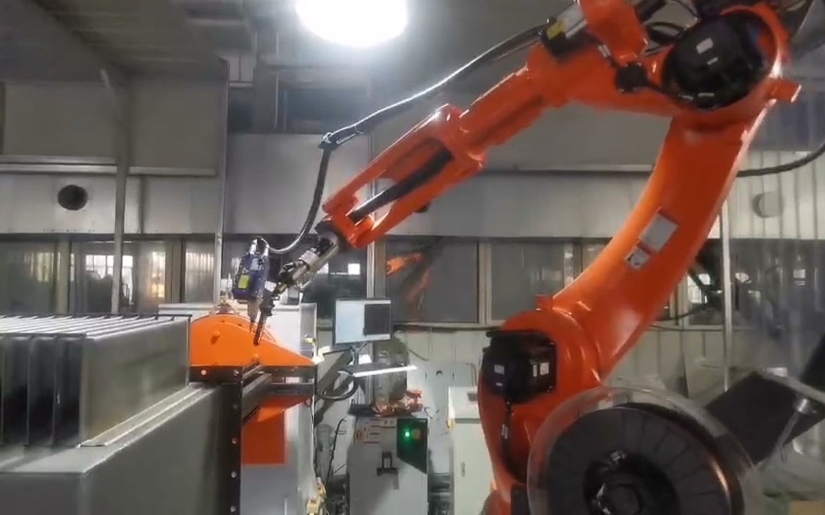 Rectangular transformer tank with corrugated wall sections at a robotic welding station