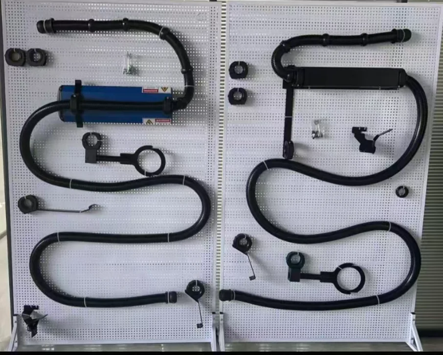 Robot dress pack parts laid out on a display board: corrugated hoses, fixing brackets, clamps, splitters and retraction boxes