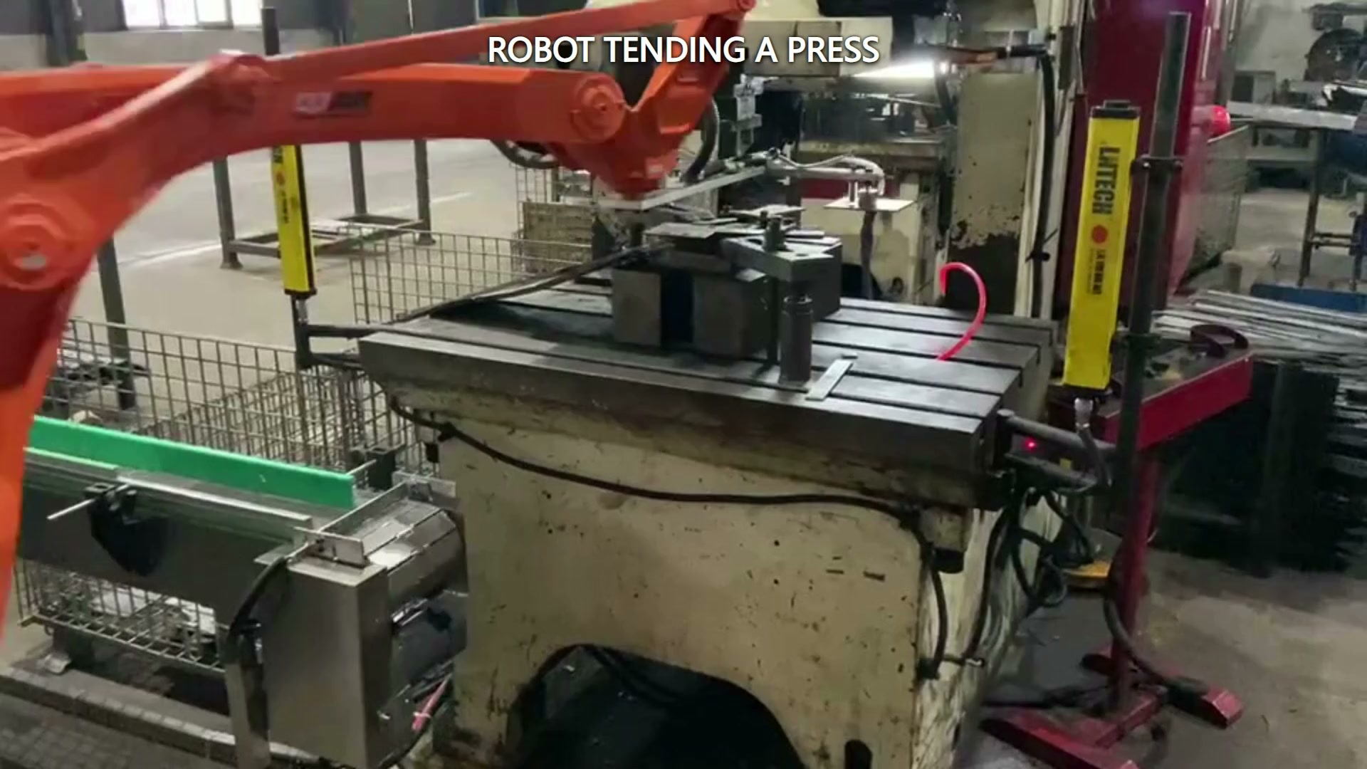 The robot end tool reaches into the die area of the press station