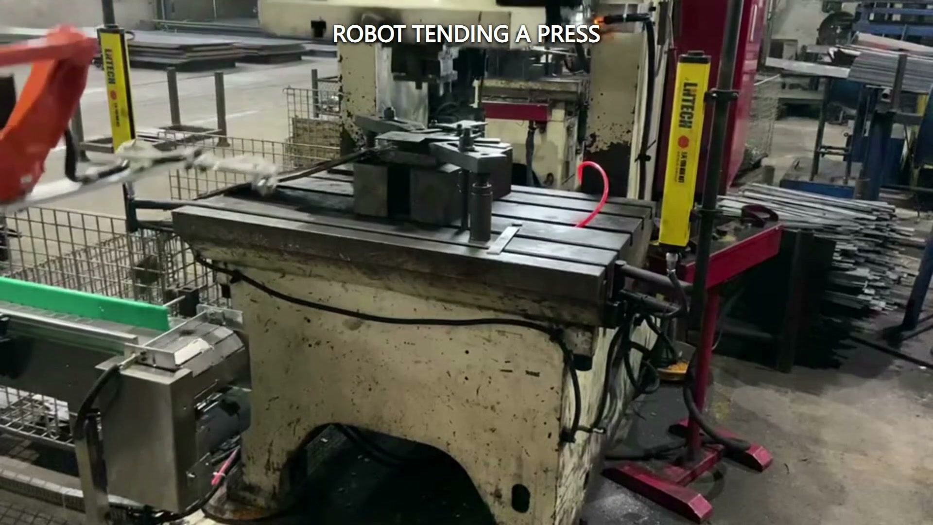 The small conveyor beside the press forms the transfer area.