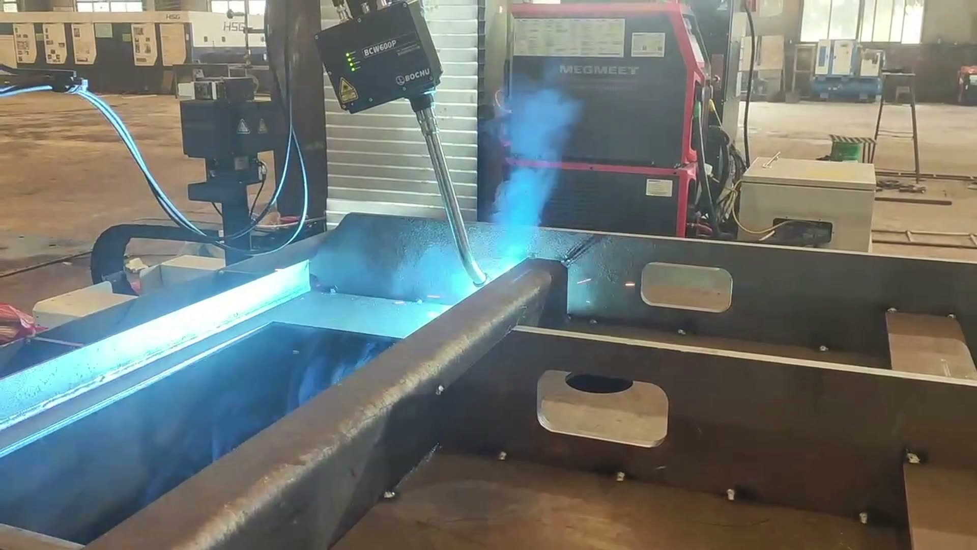 Welding torch and arc positioned beside a visible seam and reinforcing rib