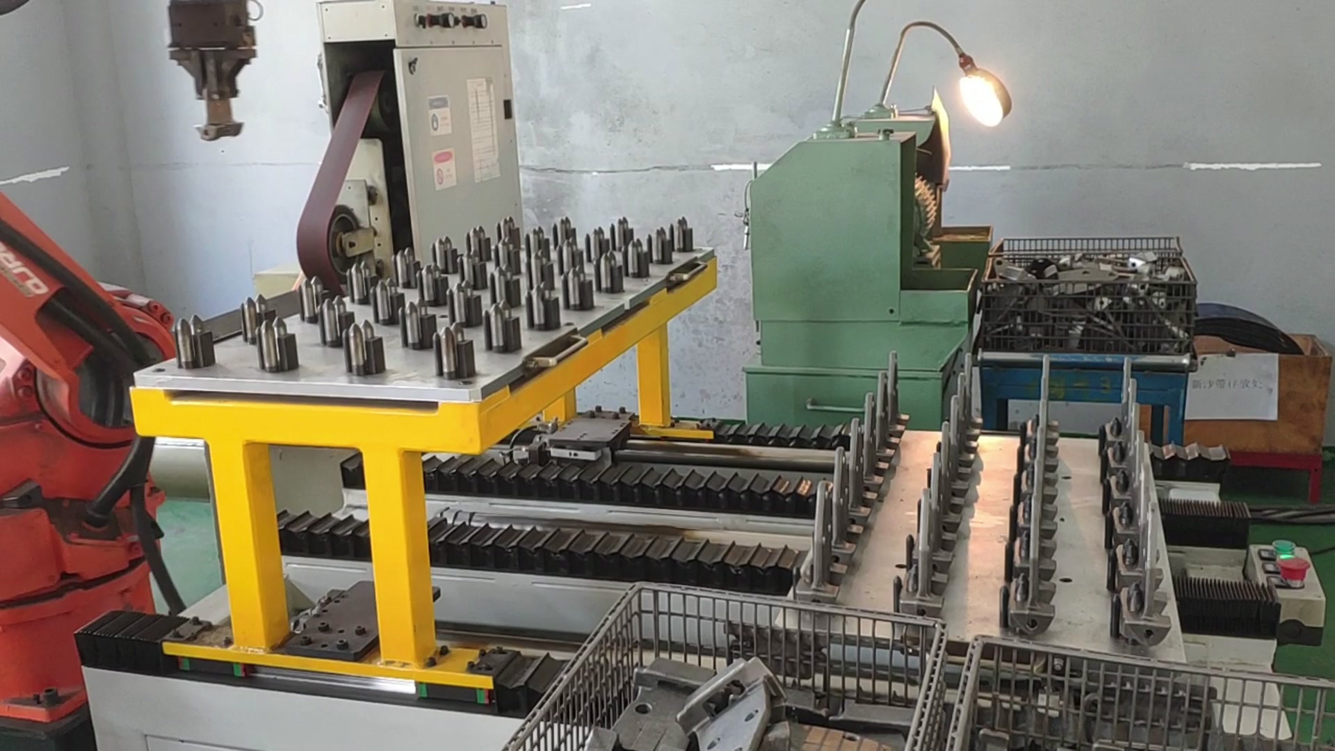 Locating rack beside the robot, with rows of hinges on the fixture table behind it