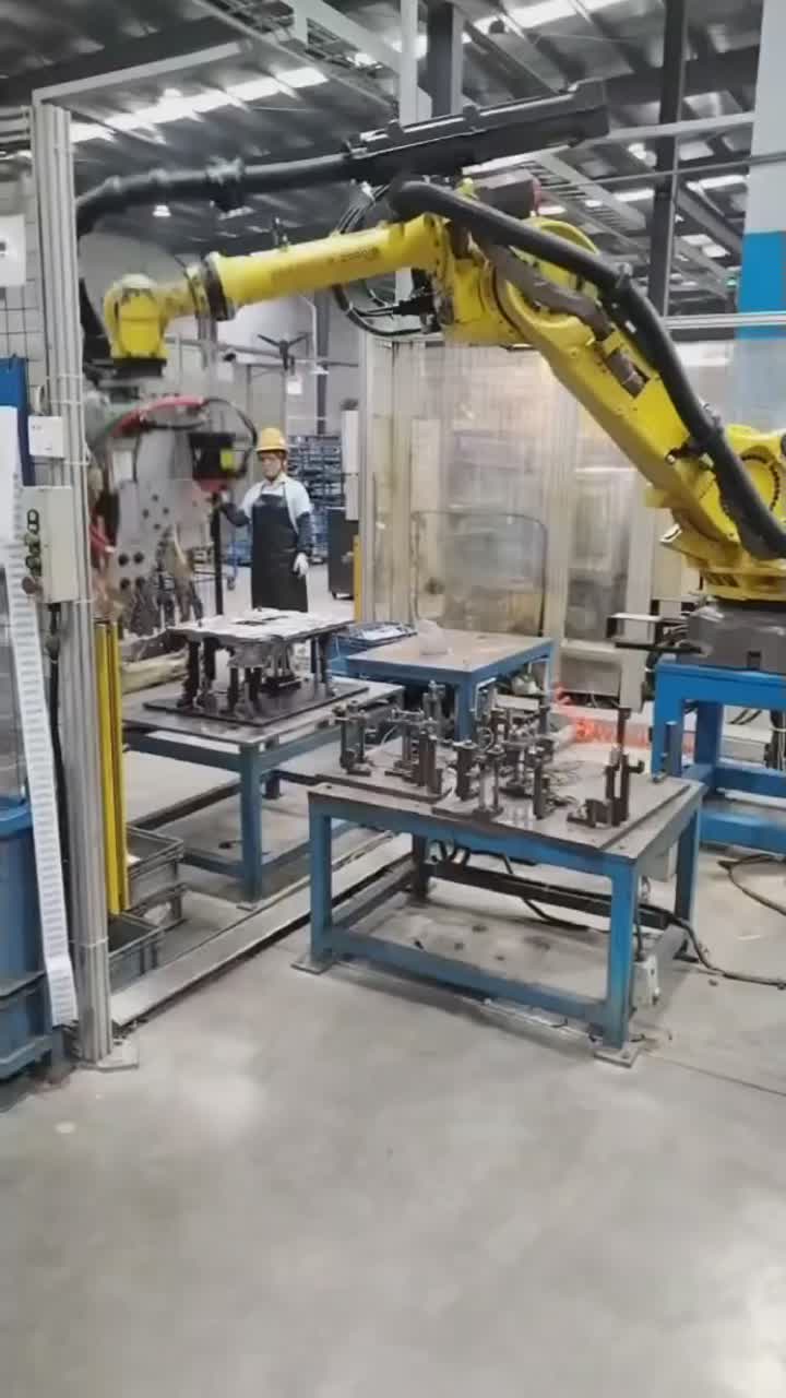 Robot carrying a spot-welding gun above a clamped metal assembly