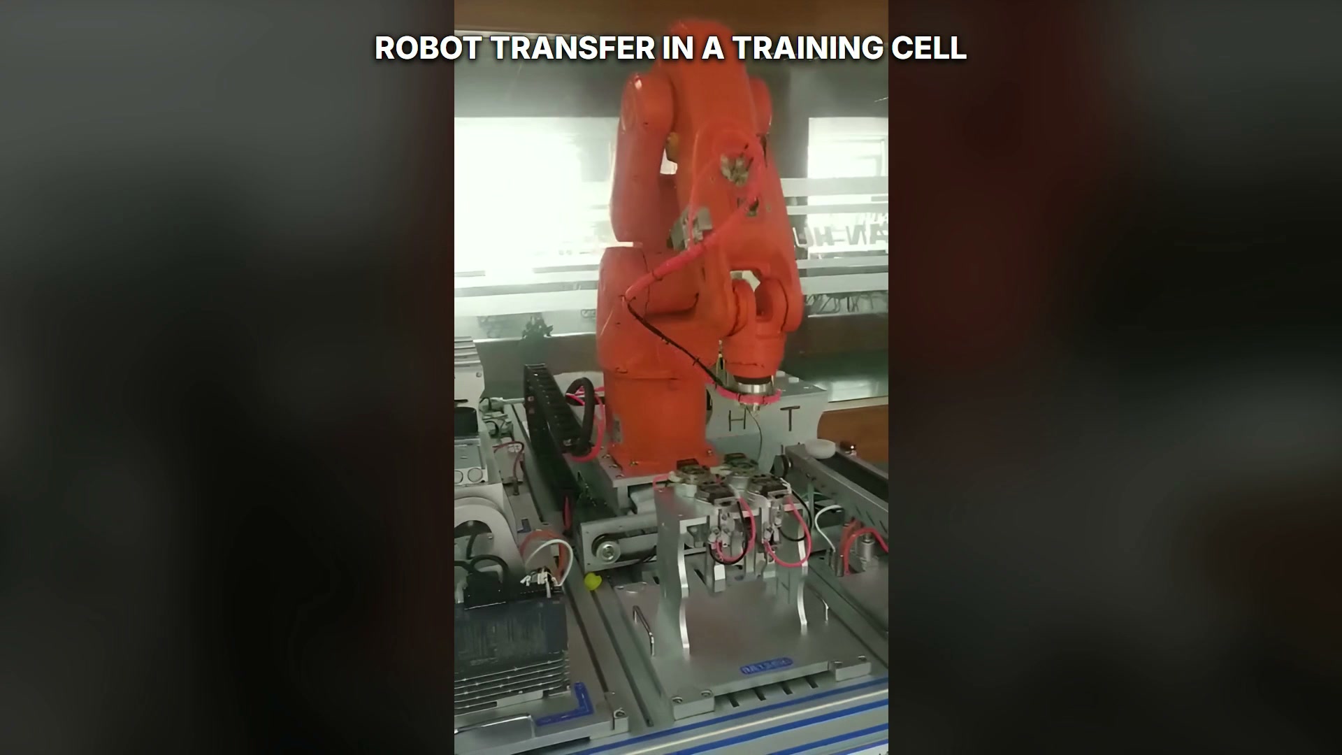 Robot positioned in the multi-station work cell with several fixtures in view.