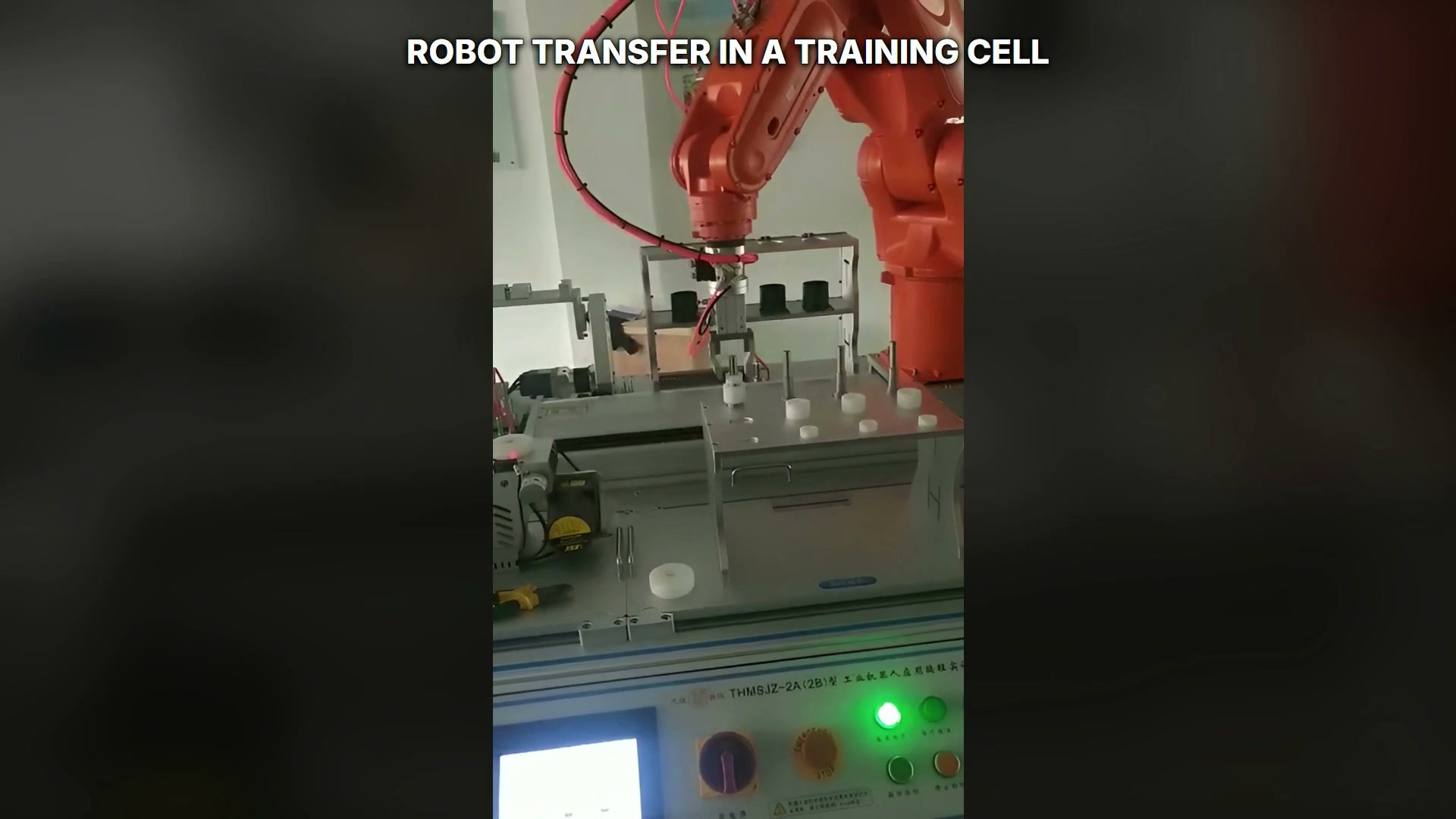 Orange robot approaching one fixture zone in the multi-station cell.