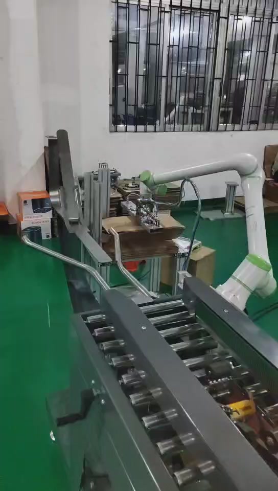 Robot tool approaching a stack of flat carton blanks