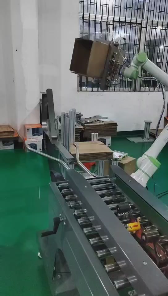 Robot holding an opened carton above a roller conveyor
