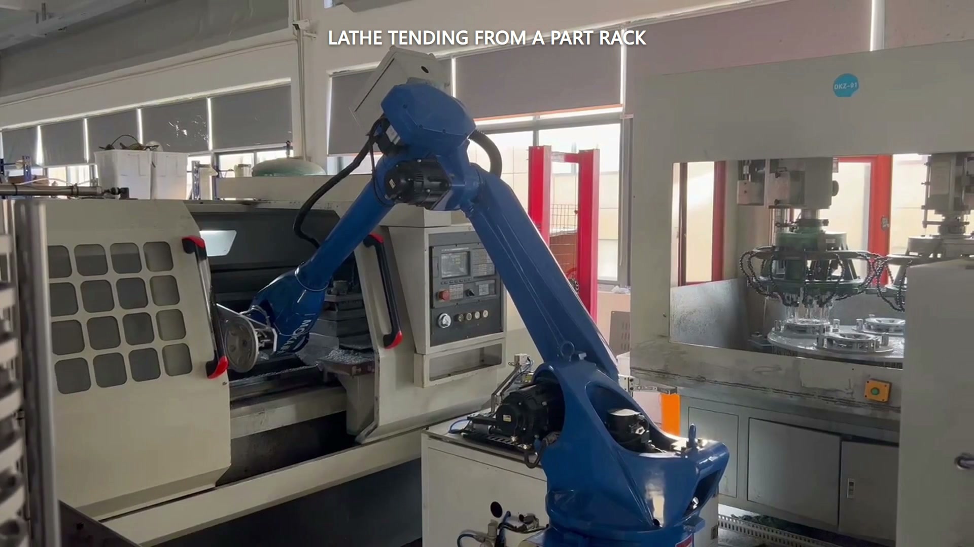 The robot performs a service movement at the open lathe.