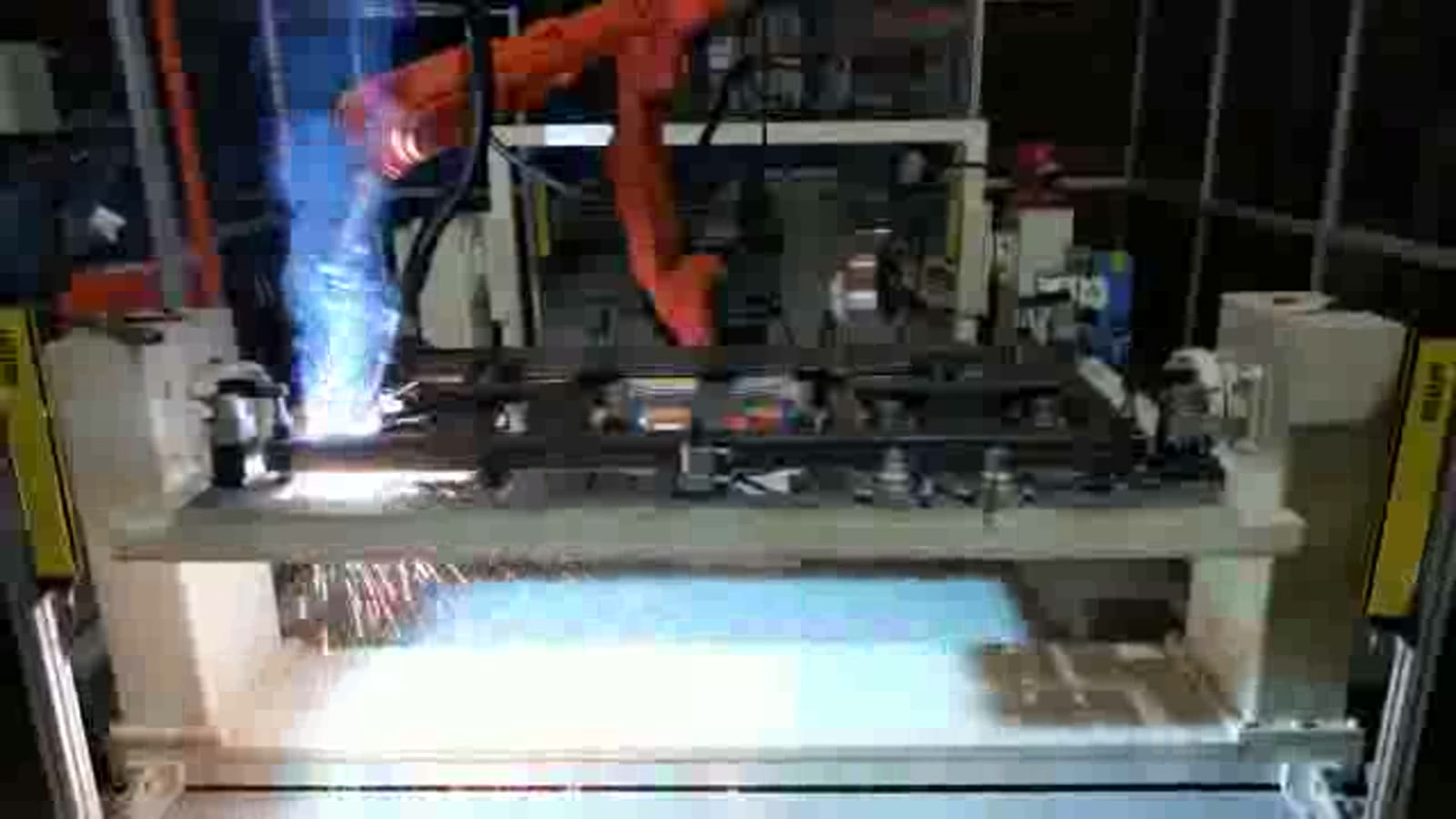 Welding torch at a joint of the steel tube frame with a bright arc and sparks
