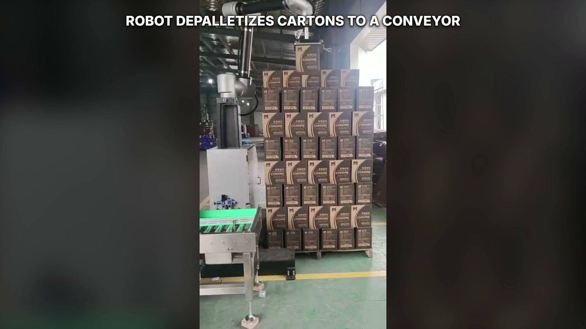 Robot holding one carton above the right-hand stacked load.