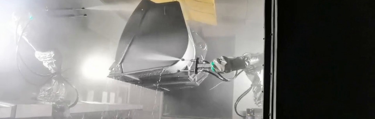 A suspended sheet-metal part is in front of the lance, with its front surface and spray direction visible.